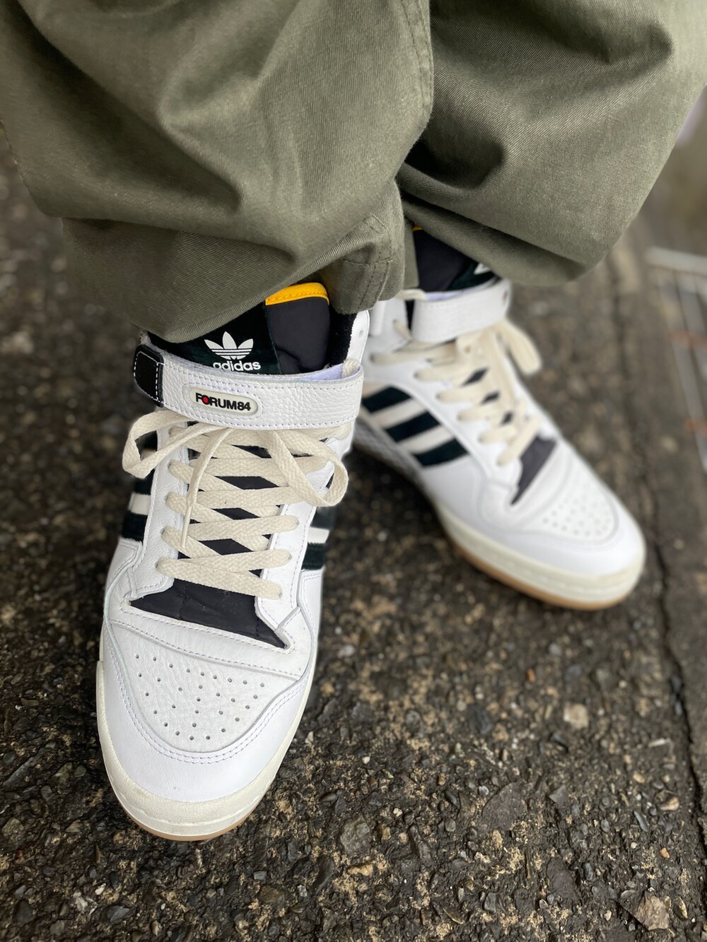 ホワイト系のスニーカー、グリーン系のその他パンツ、グリーン系のダウンベストを着用したメンズの春コーディネートの3枚目の写真