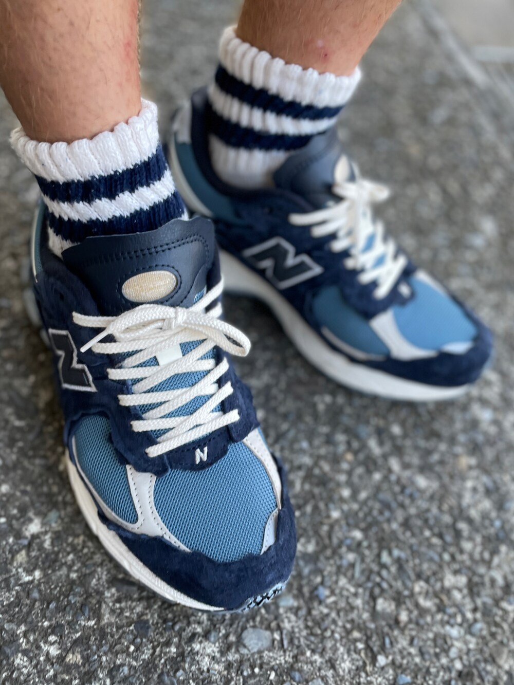 ブルー系のスニーカー、ブルー系のデニムパンツ、ブラック系のTシャツ/カットソーを着用したメンズの秋コーディネートの2枚目の写真