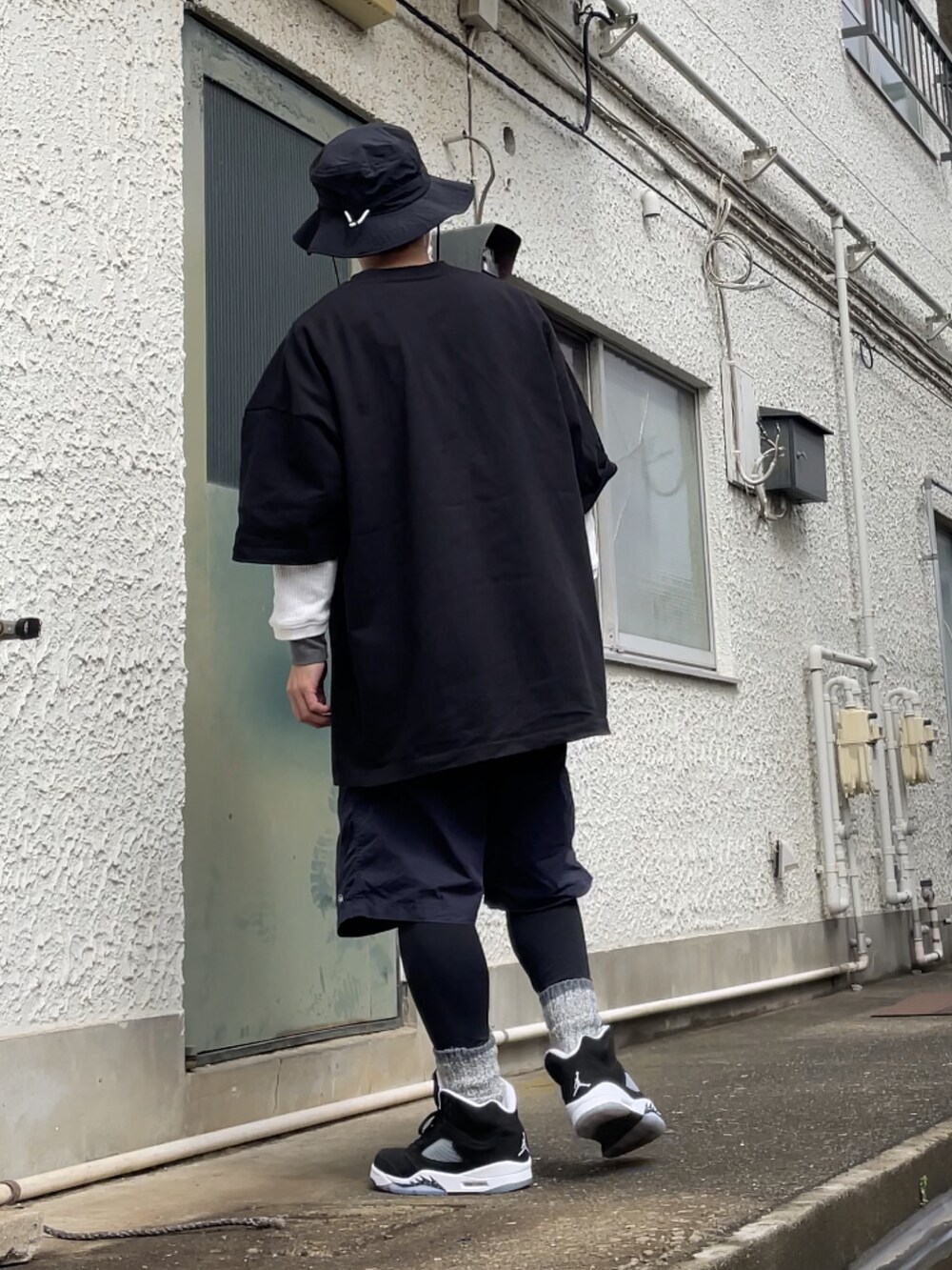 ブラック系のスニーカー、ブルー系のその他パンツ、ブラック系のTシャツ/カットソーを着用したメンズの春コーディネートの2枚目の写真