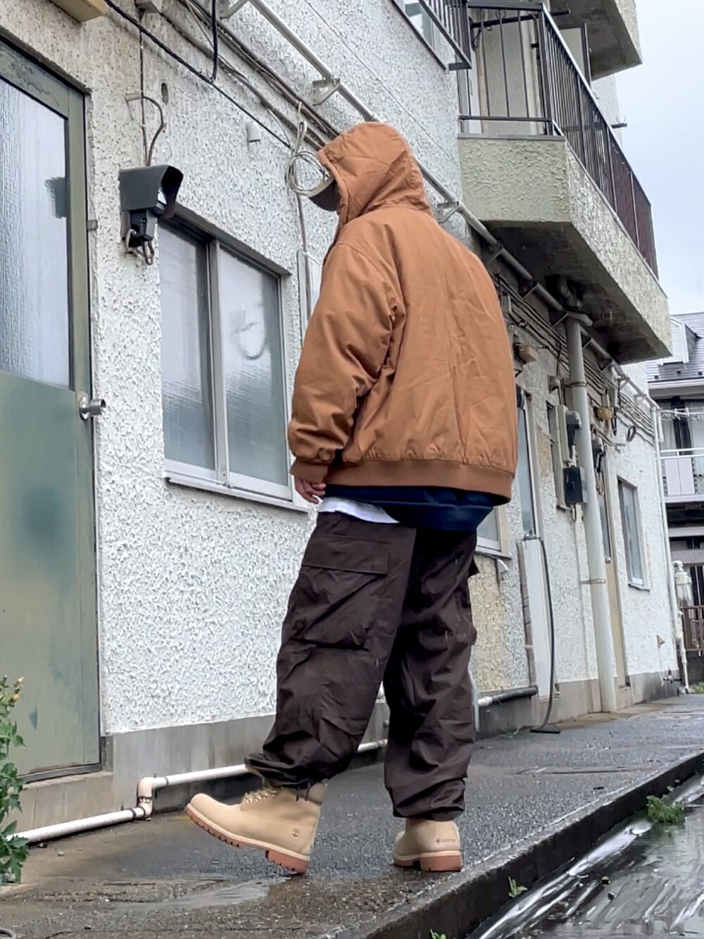 ベージュ系のブーツ、ブラウン系のカーゴパンツ、ブラウン系のブルゾンを着用したメンズの春コーディネートの2枚目の写真
