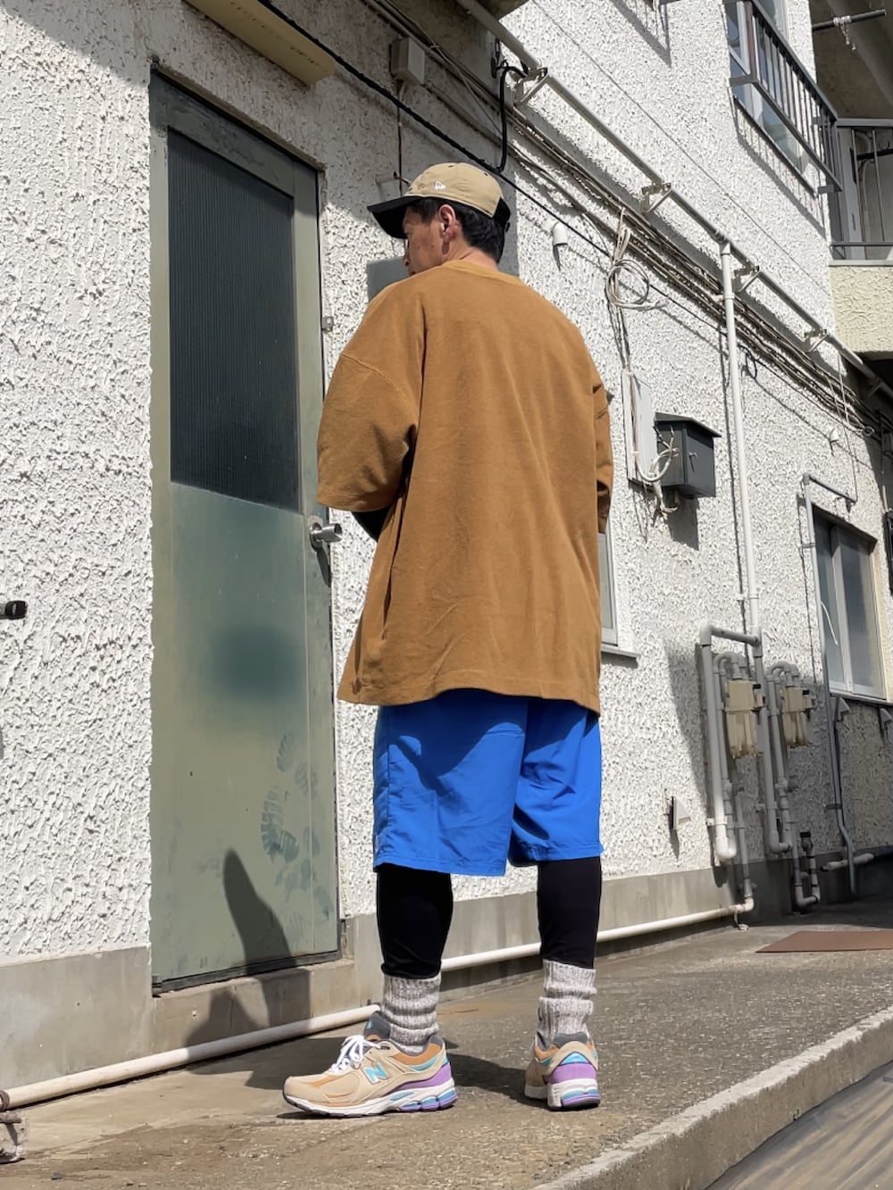 ベージュ系のスニーカー、ブルー系のその他パンツ、ブラウン系のTシャツ/カットソーを着用したメンズの春コーディネートの2枚目の写真