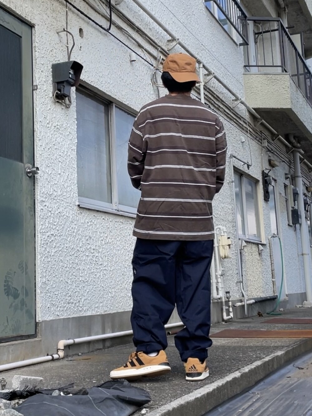 ブラウン系のスニーカー、ブルー系のその他パンツ、グレー系のTシャツ/カットソーを着用したメンズの秋コーディネートの2枚目の写真