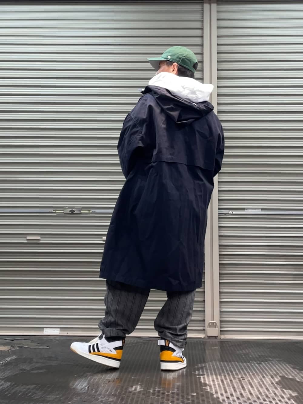 ホワイト系のスニーカー、ブラック系のその他パンツ、ブルー系のステンカラーコートを着用したメンズの冬コーディネートの2枚目の写真