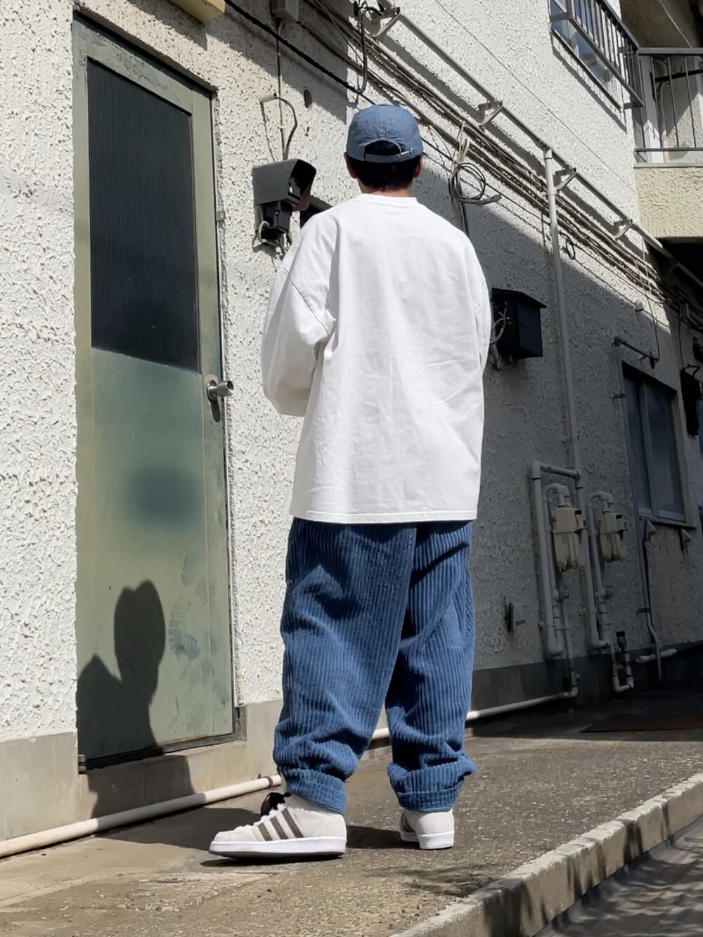 ホワイト系のスニーカー、ブルー系のその他パンツ、ホワイト系のTシャツ/カットソーを着用したメンズの春コーディネートの2枚目の写真