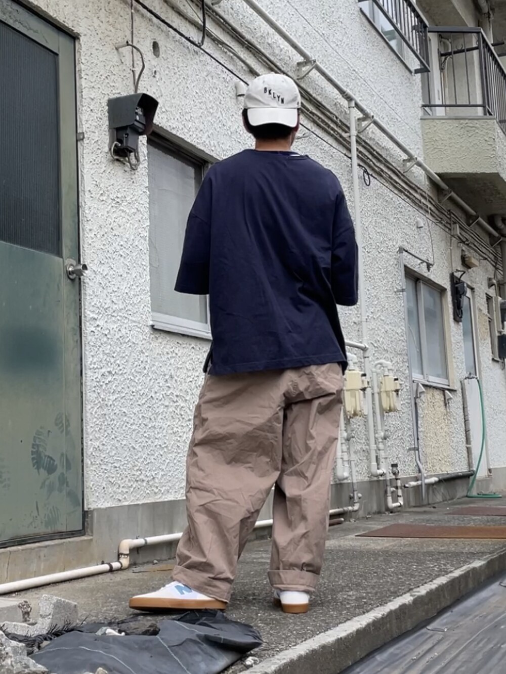 ベージュ系のパンツ、ブルー系のTシャツ/カットソー、ベージュ系のスニーカーを着用したメンズの秋コーディネートの2枚目の写真