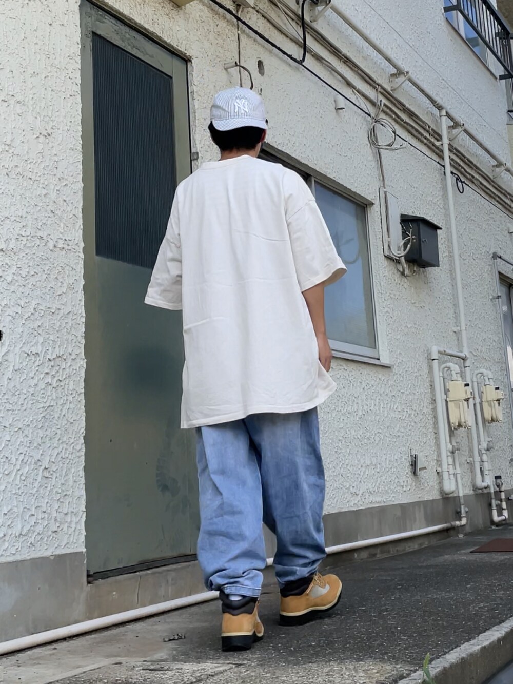 ベージュ系のブーツ、ブルー系のデニムパンツ、ベージュ系のTシャツ/カットソーを着用したメンズの秋コーディネートの2枚目の写真