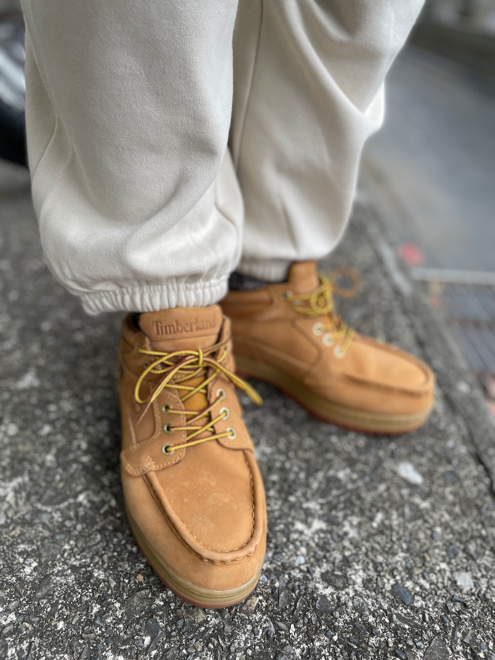 イエロー系のブーツ、ホワイト系のスウェットパンツ、ブルー系のスウェットを着用したメンズの冬コーディネートの3枚目の写真