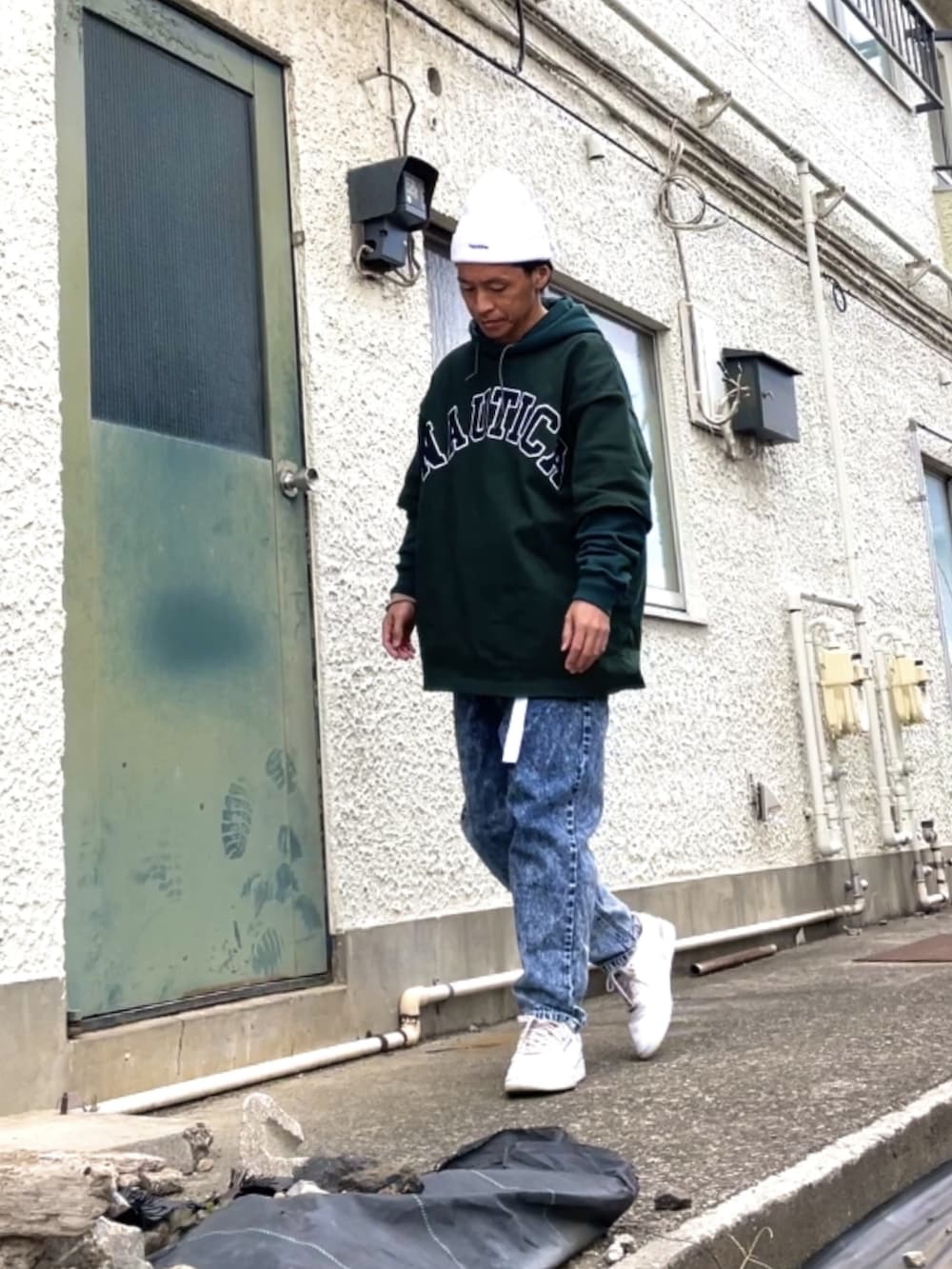 ホワイト系のスニーカー、ブルー系のデニムパンツ、グリーン系のTシャツ/カットソーを着用したメンズの冬コーディネートの2枚目の写真