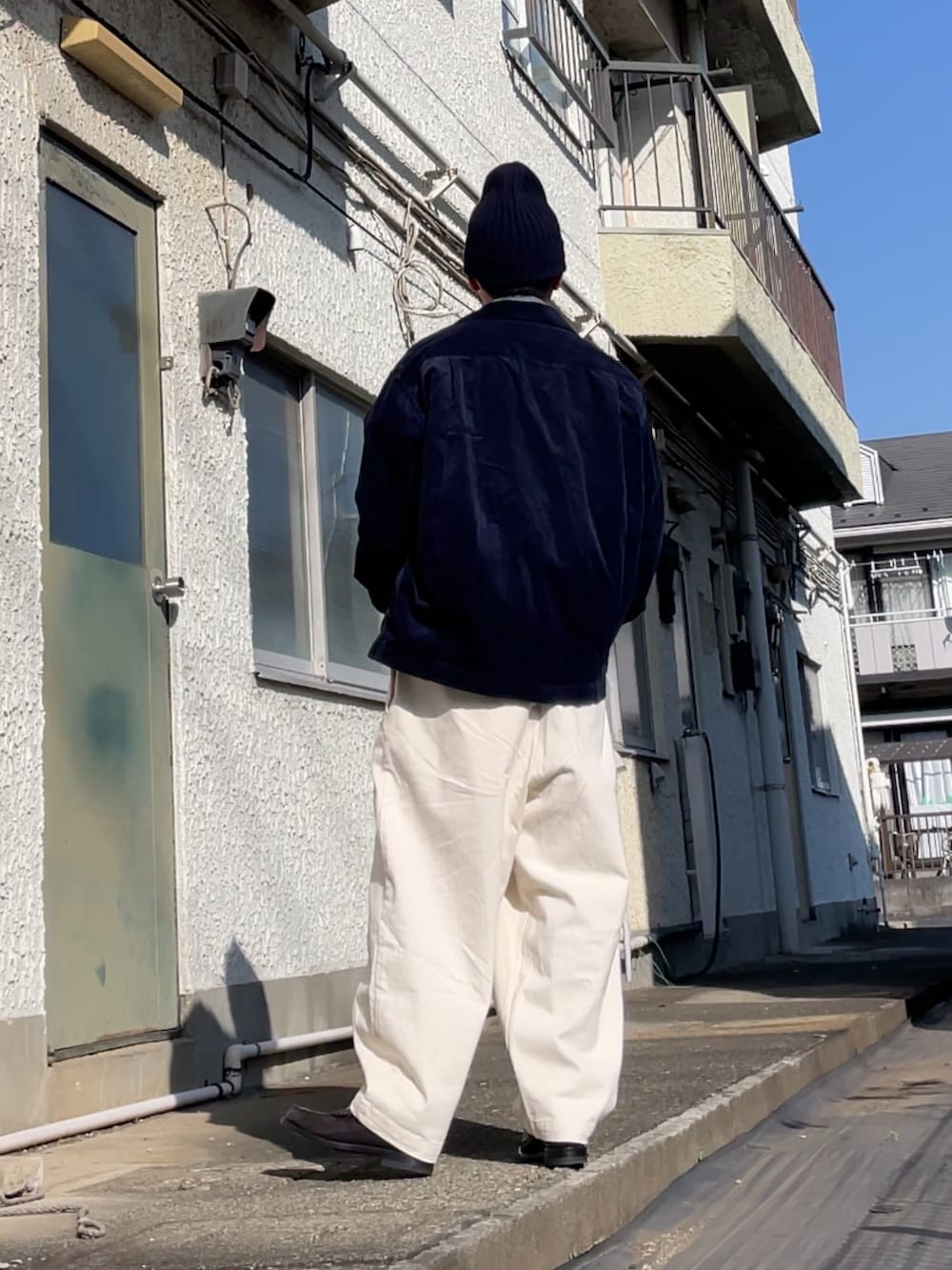 ブルー系のデニムジャケット、ブラウン系のローファー、ホワイト系のデニムパンツを着用したメンズの冬コーディネートの2枚目の写真