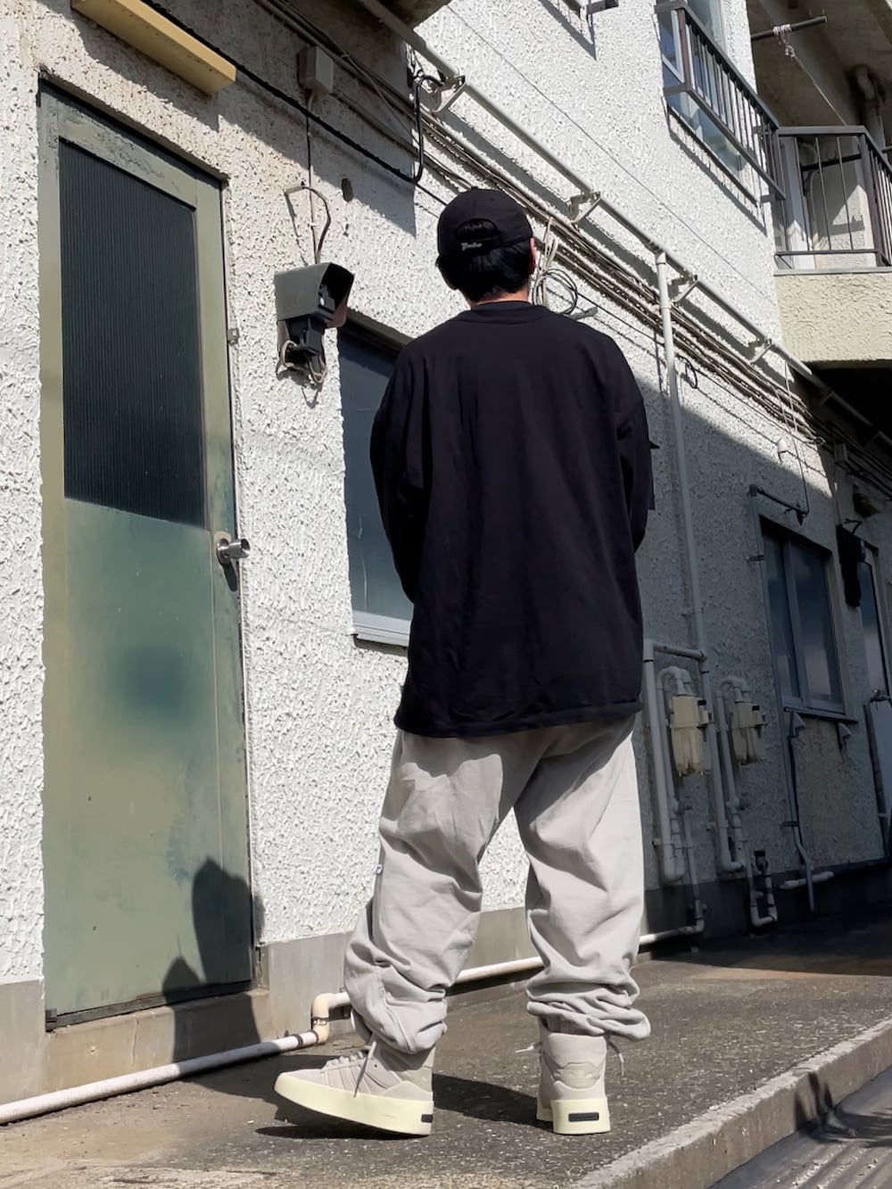 ベージュ系のスニーカー、グレー系のその他パンツ、ブラック系のTシャツ/カットソーを着用したメンズの春コーディネートの2枚目の写真