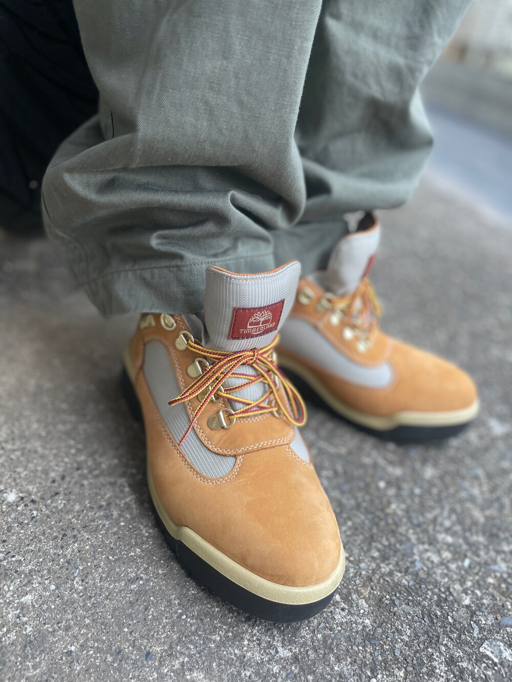 ベージュ系のブーツ、グリーン系のその他パンツ、ホワイト系のTシャツ/カットソーを着用したメンズの秋コーディネートの3枚目の写真