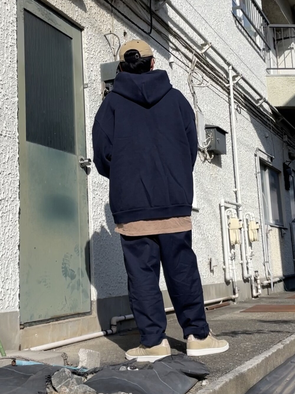 ベージュ系のスニーカー、ブルー系のチノパンツ、ブルー系のパーカーを着用したメンズの秋コーディネートの2枚目の写真