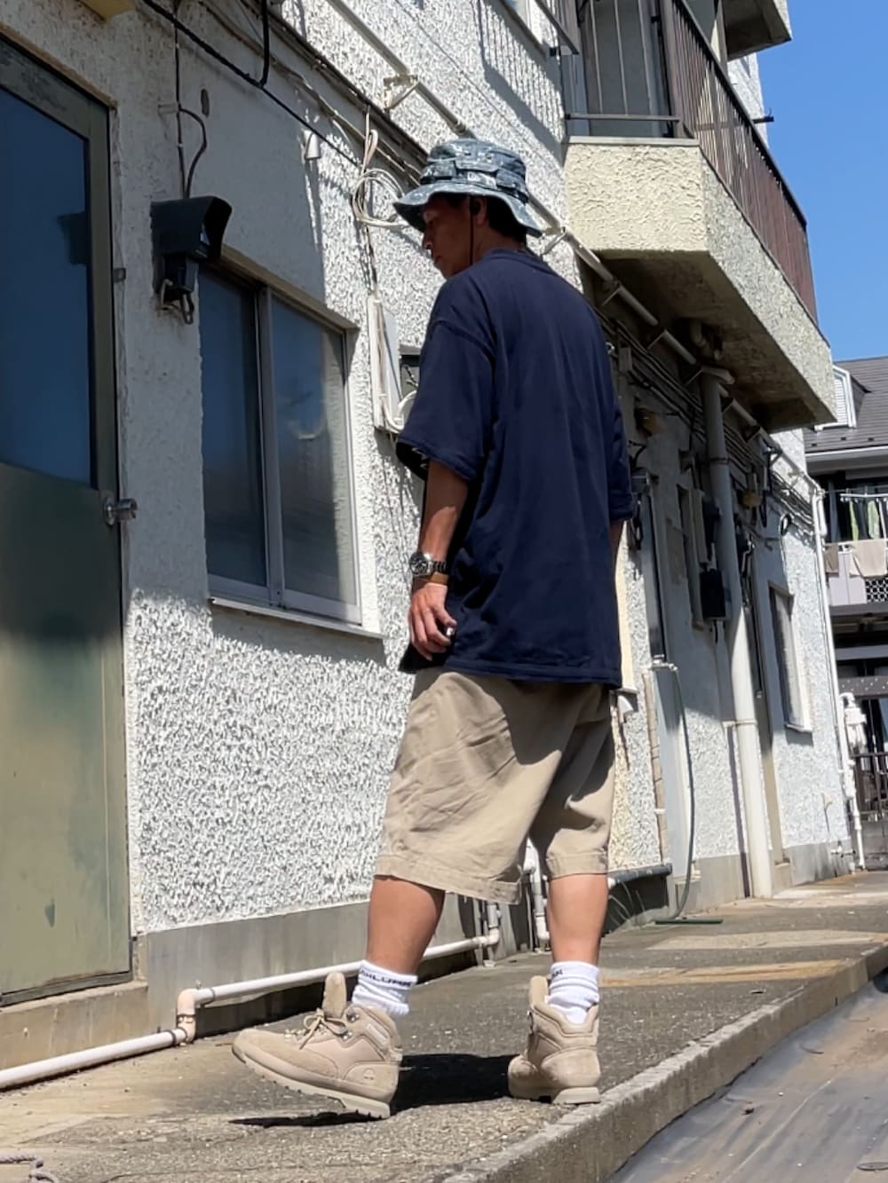 ブルー系のTシャツ/カットソー、ベージュ系のチノパンツ、ベージュ系のブーツを着用したメンズの秋コーディネートの2枚目の写真