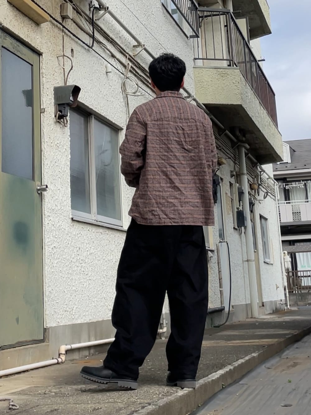 ブラウン系のシャツ/ブラウス、ブラック系のデニムパンツ、ブラック系のブーツを着用したメンズの春コーディネートの2枚目の写真