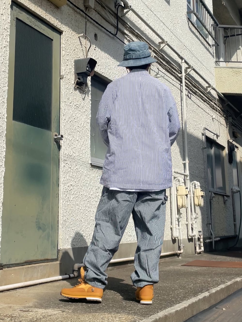 ブラウン系のブーツ、その他のデニムパンツ、ブルー系のテーラードジャケットを着用したメンズの春コーディネートの2枚目の写真