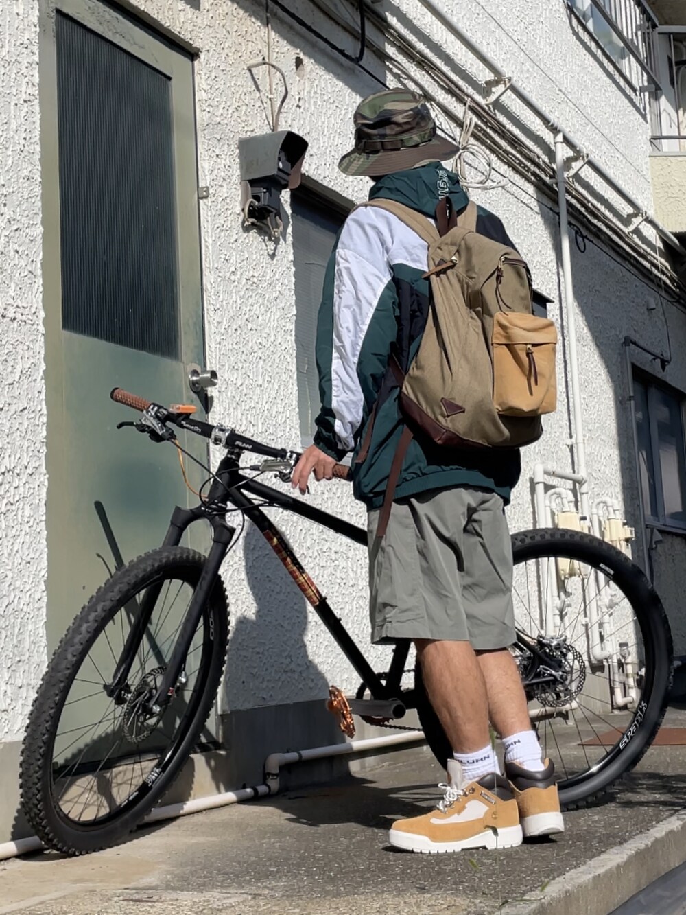 ブラウン系のブーツ、ブラウン系のその他パンツ、グリーン系のマウンテンパーカーを着用したメンズの秋コーディネートの2枚目の写真