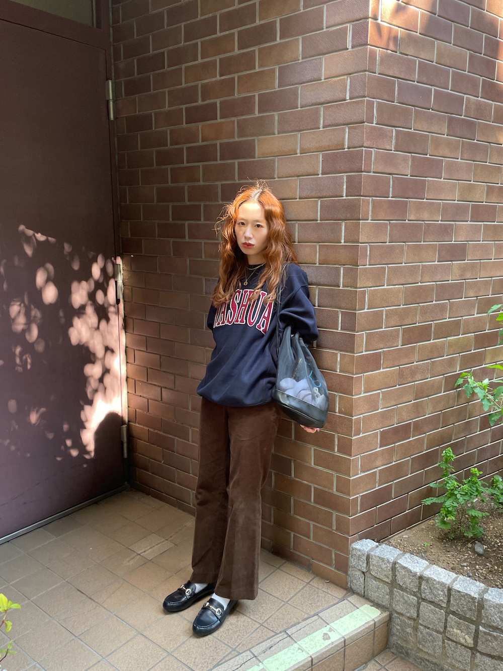 ブルー系のスウェット、ブラック系のローファーを着用したレディースの秋コーディネートの2枚目の写真