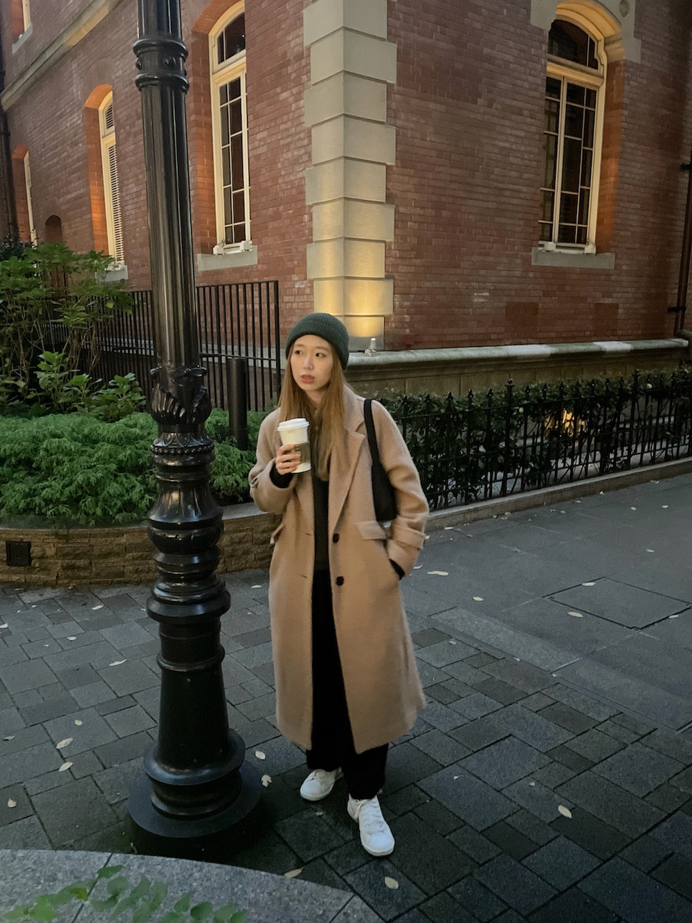 ブラック系のハンドバッグを着用したレディースの冬コーディネートの2枚目の写真