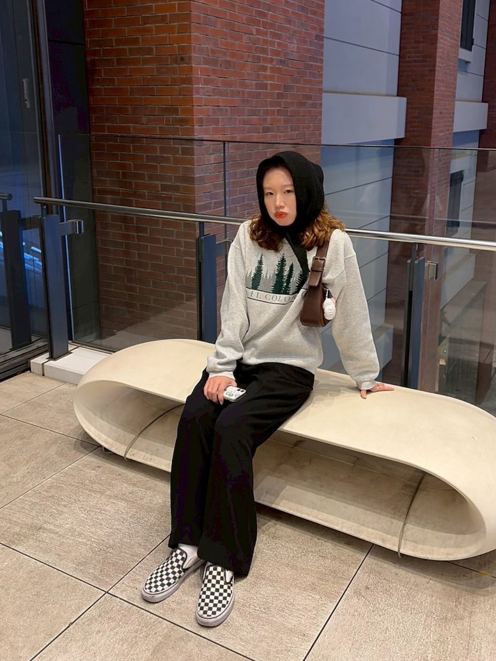 グレー系のスウェット、ブラウン系のショルダーバッグを着用したレディースの秋コーディネートの2枚目の写真