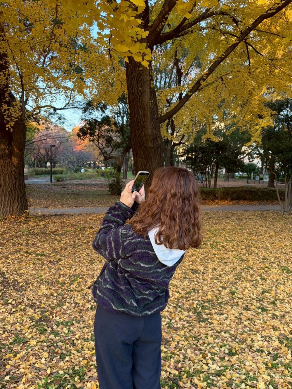 パープル系のジャケット/アウター、ブルー系のパンツを着用したレディースの秋コーディネートの3枚目の写真