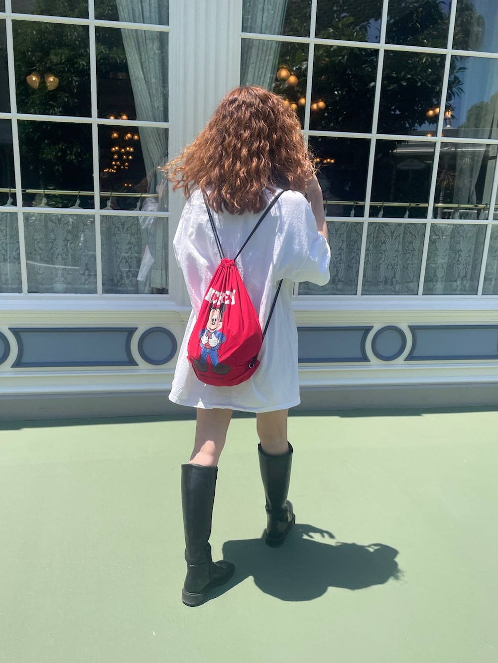 ホワイト系のTシャツ/カットソー、レッド系のバックパック/リュックを着用したレディースの春コーディネートの2枚目の写真