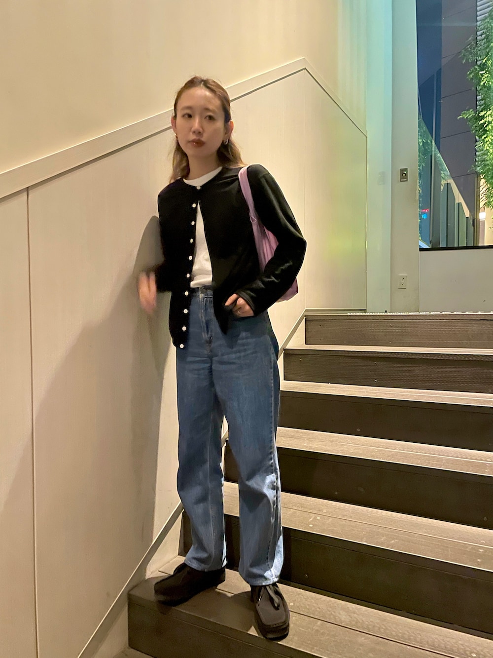 ブラック系のカーディガン/ボレロ、ブルー系のデニムパンツ、パープル系のエコバッグ/サブバッグを着用したレディースの春コーディネートの2枚目の写真