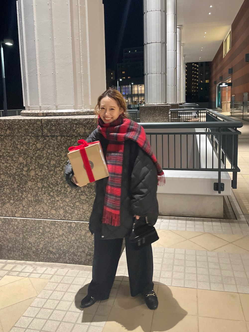 ブラック系のダウンジャケット/コート、ブラック系のローファー、レッド系のマフラーを着用したレディースの冬コーディネートの2枚目の写真