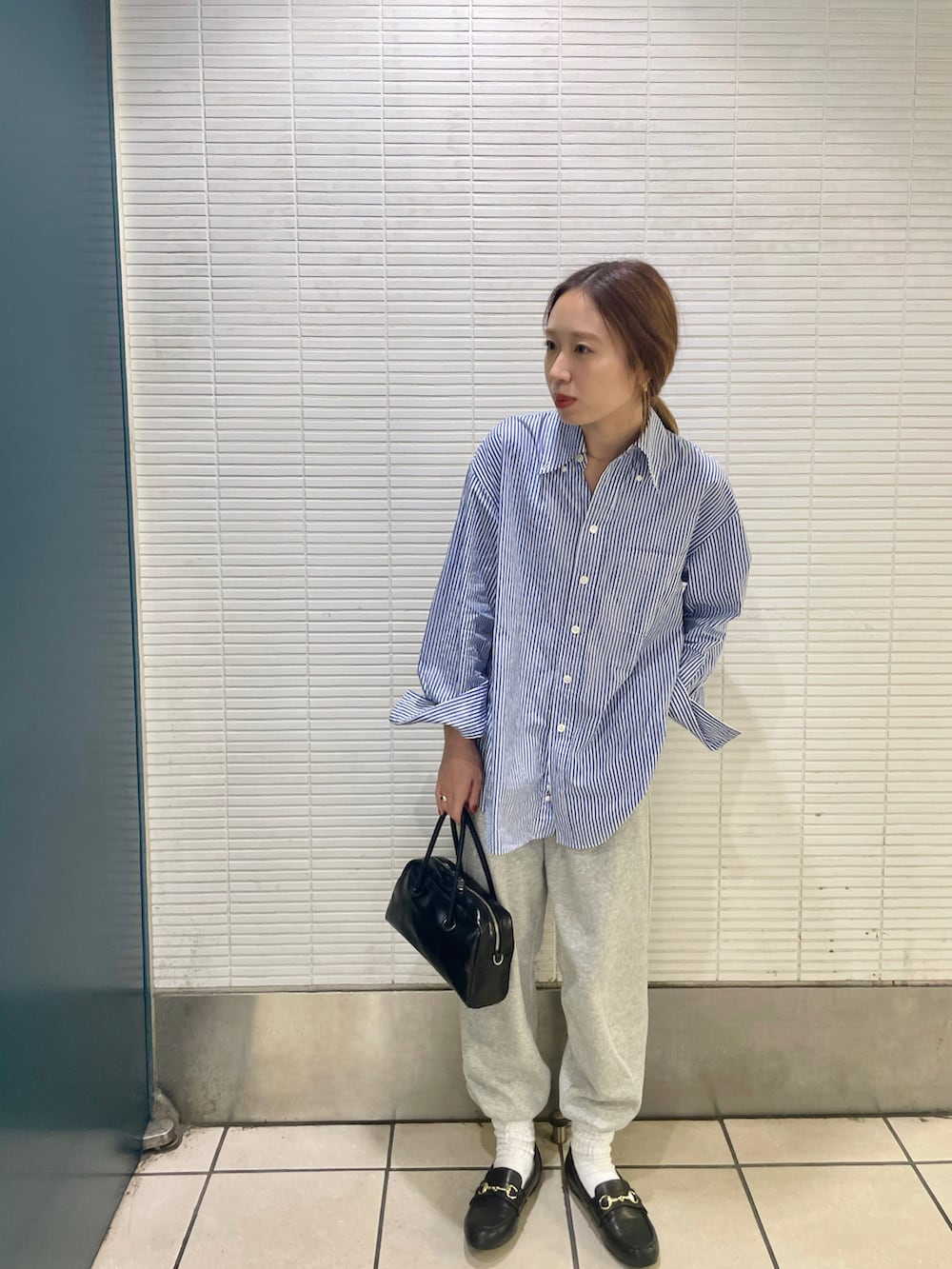 ブルー系のシャツ/ブラウス、グレー系のスウェットパンツ、ブラック系のローファーを着用したレディースの秋コーディネートの2枚目の写真