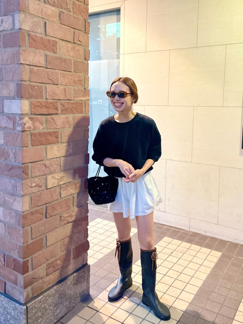 ホワイト系のその他パンツ、ブラック系のショルダーバッグ、ブラック系のレインシューズを着用したレディースの秋コーディネートの2枚目の写真