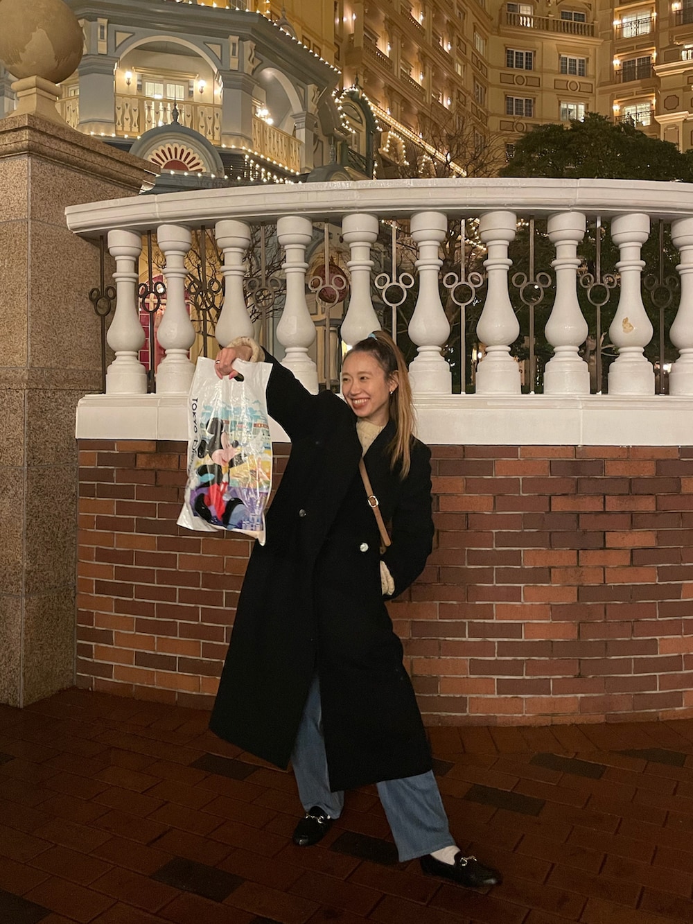 ブラック系のチェスターコート、ブラック系のローファーを着用したレディースの冬コーディネートの2枚目の写真