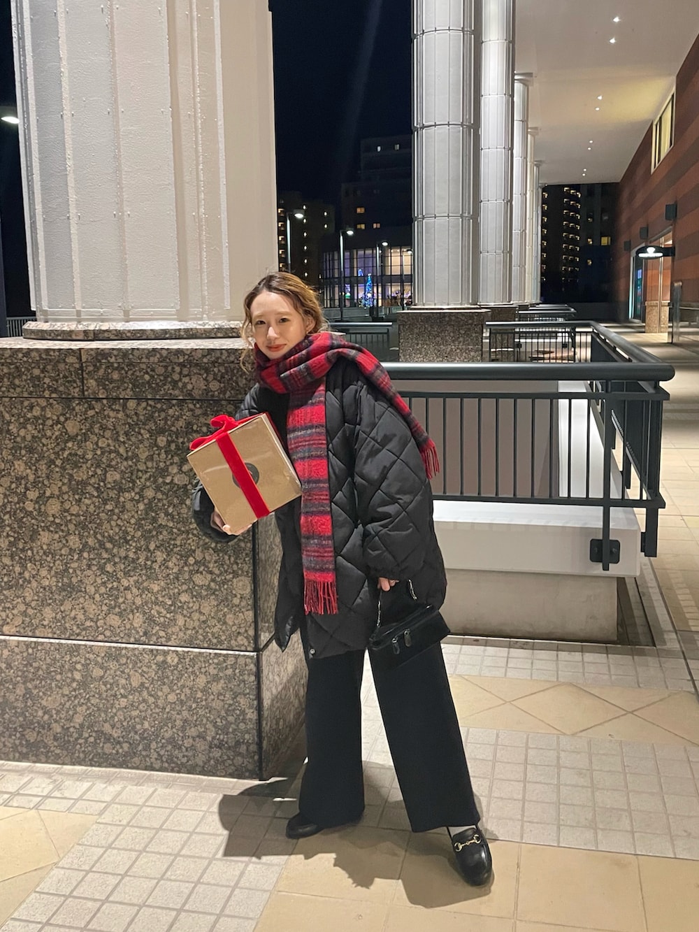 ブラック系のダウンジャケット/コート、ブラック系のローファー、レッド系のマフラーを着用したレディースの冬コーディネートの3枚目の写真