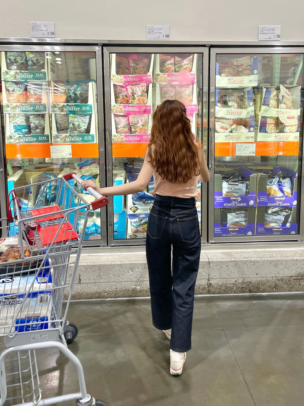 オレンジ系のキャミソール、ブルー系のデニムパンツを着用したレディースの夏コーディネートの3枚目の写真