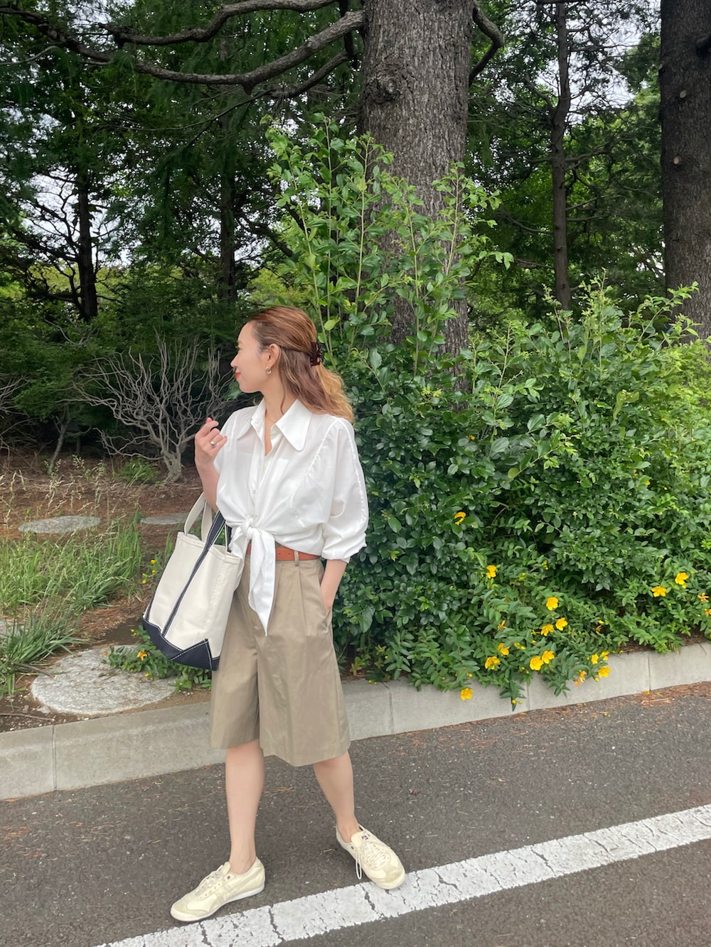 ブラック系のトートバッグ、ベージュ系のスニーカーを着用したレディースの春コーディネートの2枚目の写真