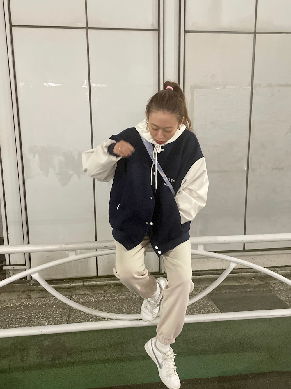 ブルー系のスタジャン、ブルー系のショルダーバッグ、ベージュ系のパンツを着用したレディースの秋コーディネートの3枚目の写真