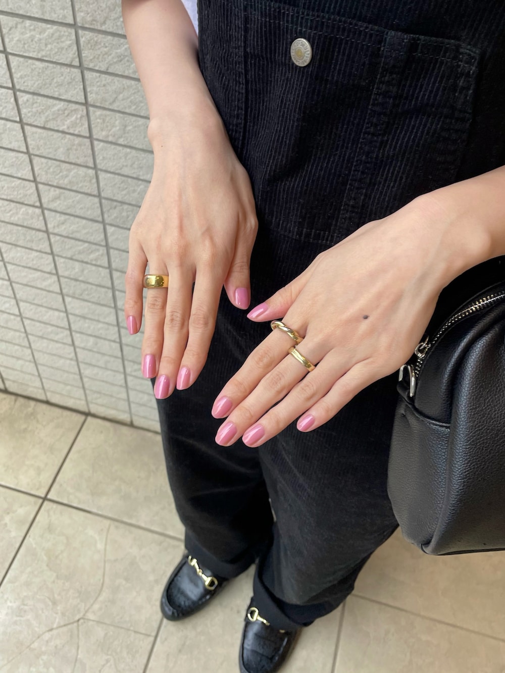 ブラック系のサロペット/オーバーオール、ブラック系のハンドバッグ、ブラック系のローファーを着用したレディースの春コーディネートの2枚目の写真