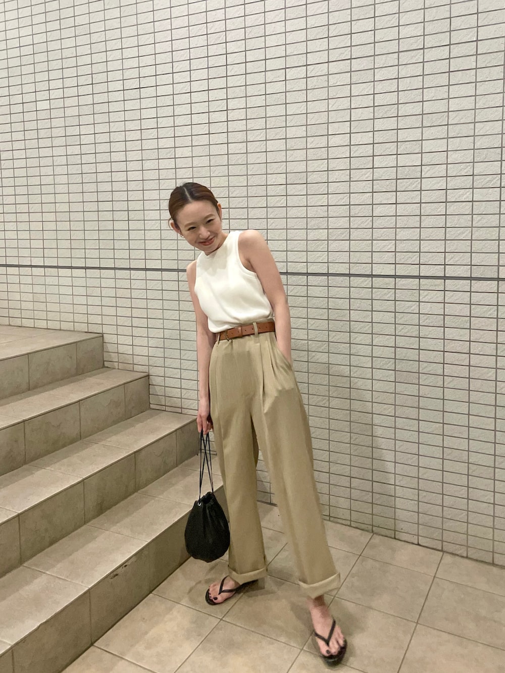 ホワイト系のタンクトップ、ベージュ系のセットアップ、ブラック系のハンドバッグを着用したレディースの夏コーディネートの2枚目の写真