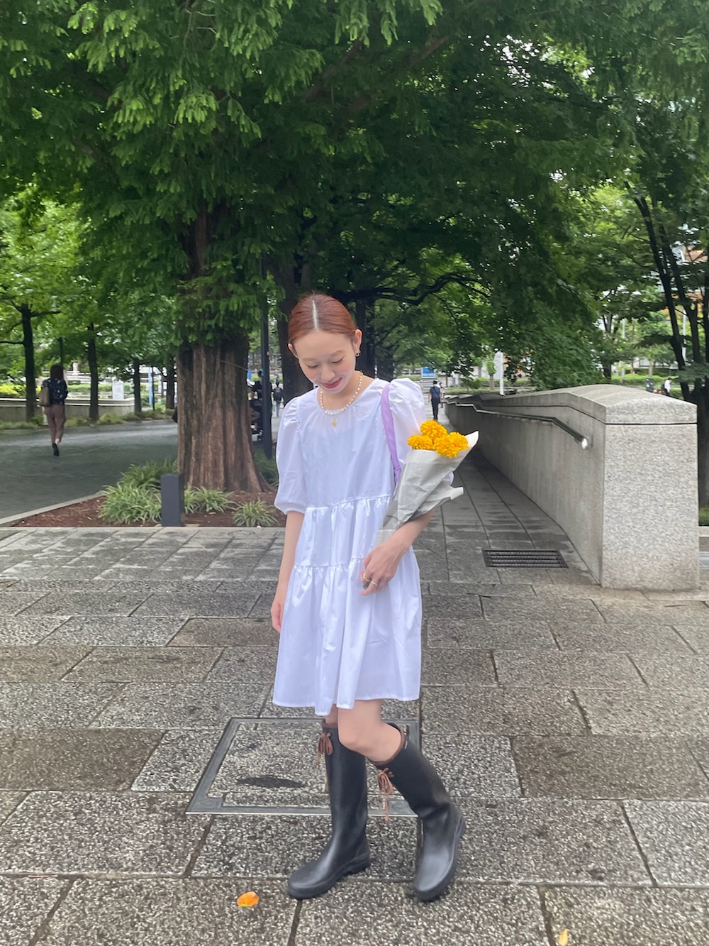 ホワイト系のワンピース、ブラック系のレインシューズを着用したレディースの夏コーディネートの3枚目の写真