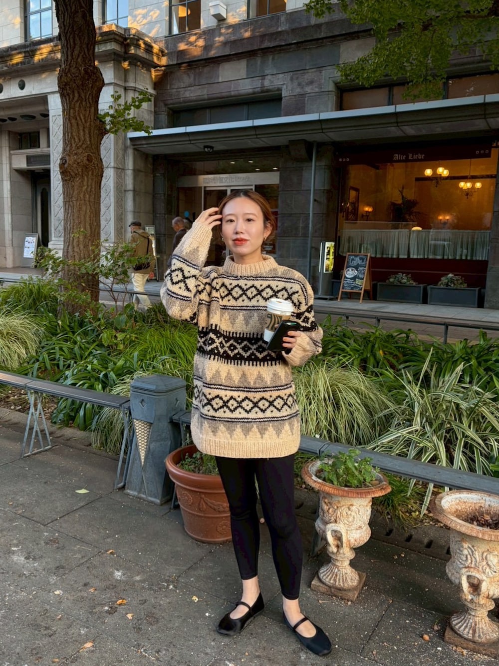 ベージュ系のニット/セーター、ブラック系のバレエシューズを着用したレディースの秋コーディネートの2枚目の写真