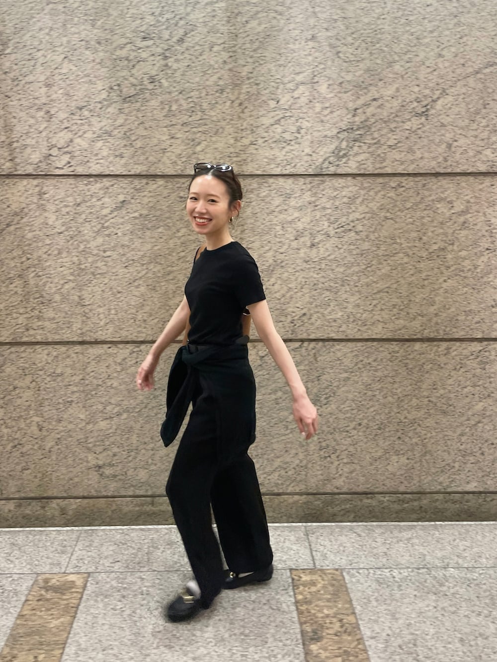 ブラック系のTシャツ/カットソー、ブラック系のスラックス、ブラック系のローファーを着用したレディースの夏コーディネートの2枚目の写真