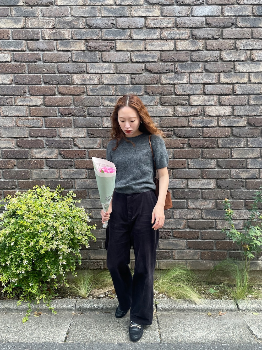 ブラック系のその他パンツ、イエロー系のハンドバッグ、グレー系のニット/セーターを着用したレディースの秋コーディネートの2枚目の写真