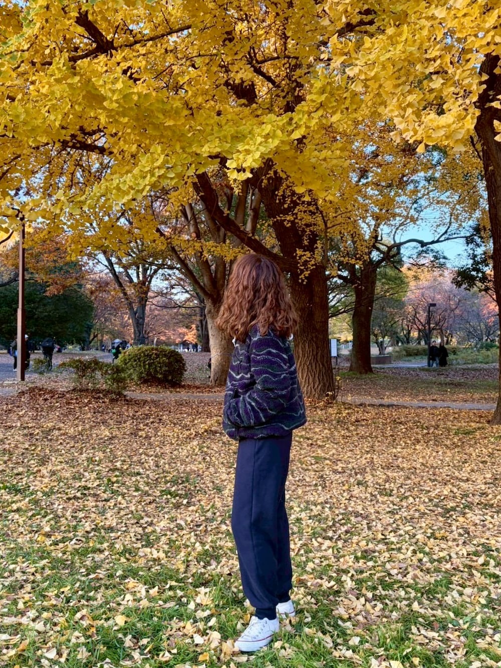 パープル系のジャケット/アウター、ブルー系のパンツを着用したレディースの秋コーディネートの2枚目の写真