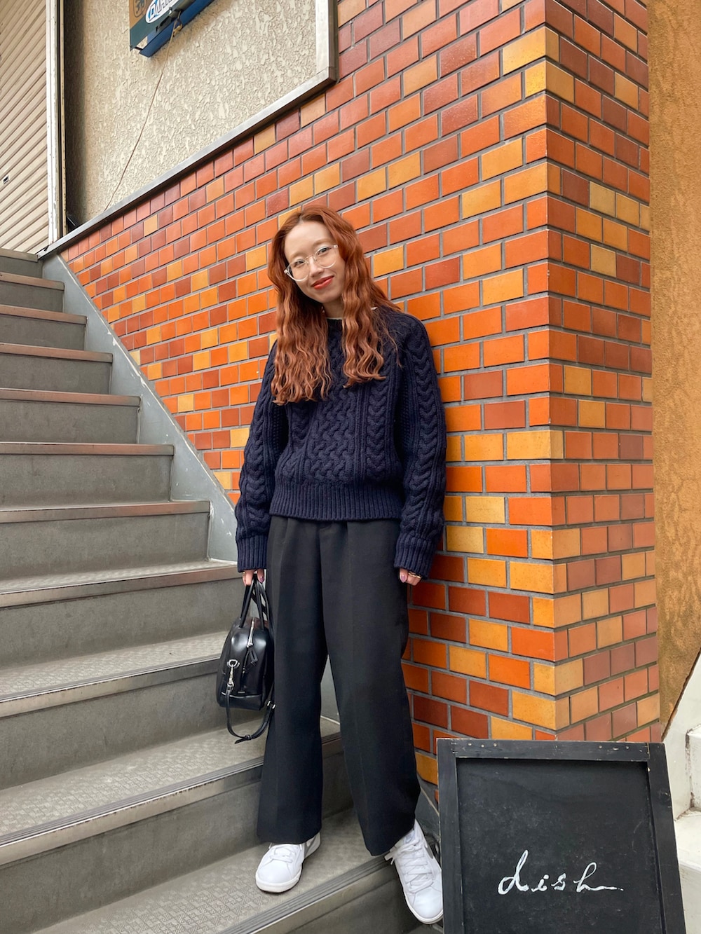 ブルー系のニット/セーター、ブラック系のボストンバッグを着用したレディースの冬コーディネートの2枚目の写真
