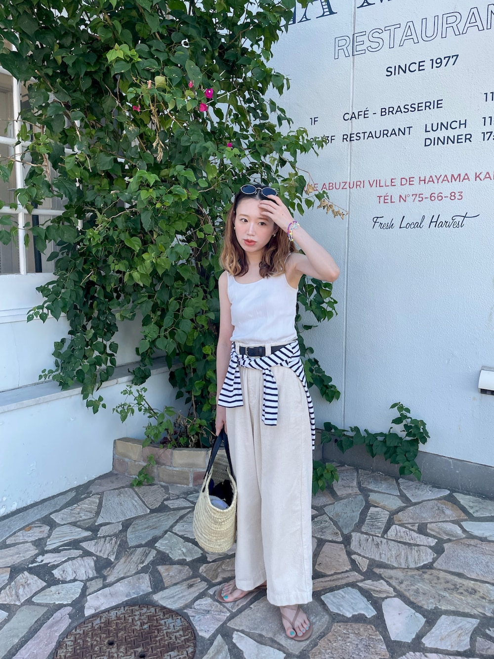 ホワイト系のタンクトップ、ホワイト系のその他パンツ、ブラック系のかごバッグを着用したレディースの秋コーディネートの2枚目の写真