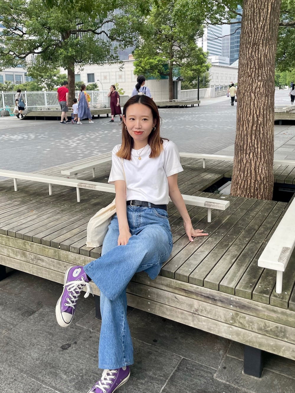 ホワイト系のTシャツ/カットソー、ブルー系のデニムパンツ、パープル系のスニーカーを着用したレディースの夏コーディネートの2枚目の写真