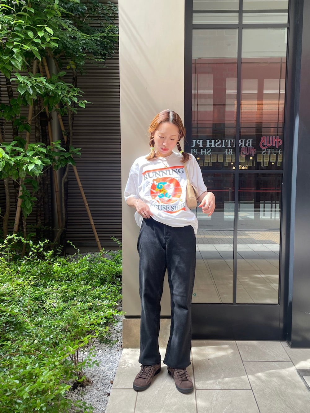 ホワイト系のTシャツ/カットソー、ブラック系のデニムパンツ、ブラウン系のスニーカーを着用したレディースの夏コーディネートの2枚目の写真