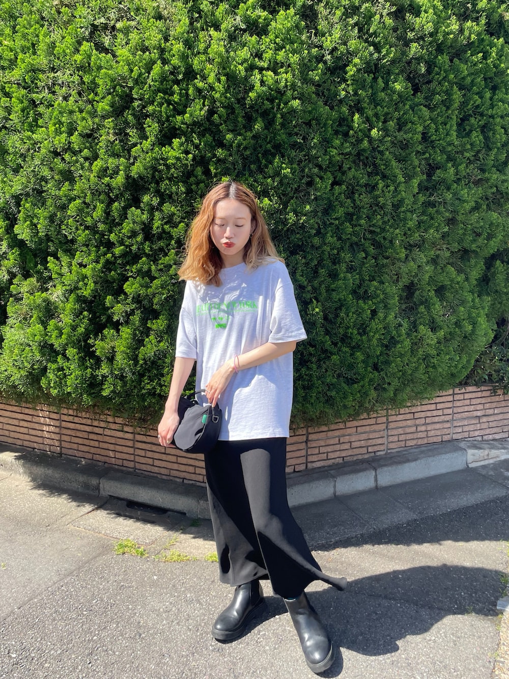 グレー系のTシャツ/カットソー、ブラック系のスカート、ブラック系のハンドバッグを着用したレディースの春コーディネートの3枚目の写真