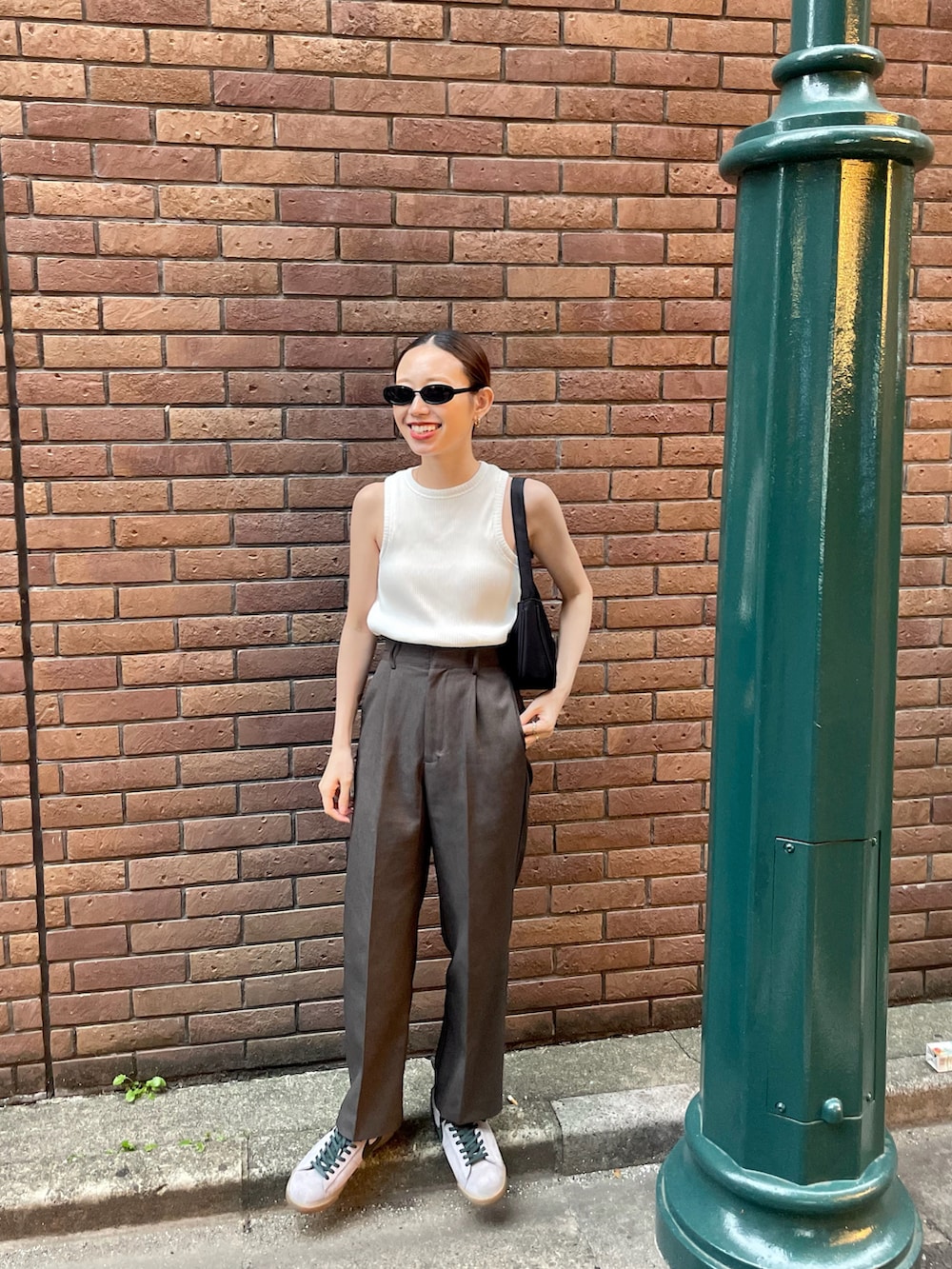 ホワイト系のタンクトップ、グレー系のスニーカーを着用したレディースの夏コーディネートの2枚目の写真