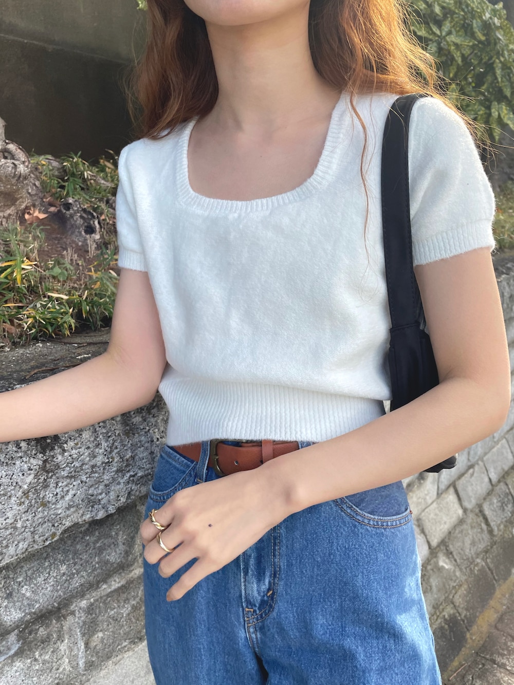 ホワイト系のニット/セーター、ブラック系のハンドバッグ、ピンク系のバレエシューズを着用したレディースの夏コーディネートの2枚目の写真