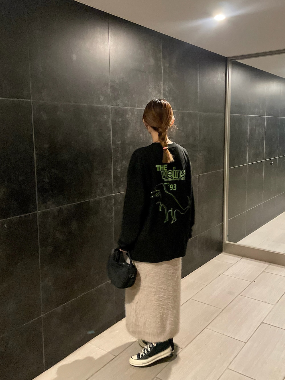 ブラック系のTシャツ/カットソー、ブラック系のハンドバッグを着用したレディースの秋コーディネートの2枚目の写真