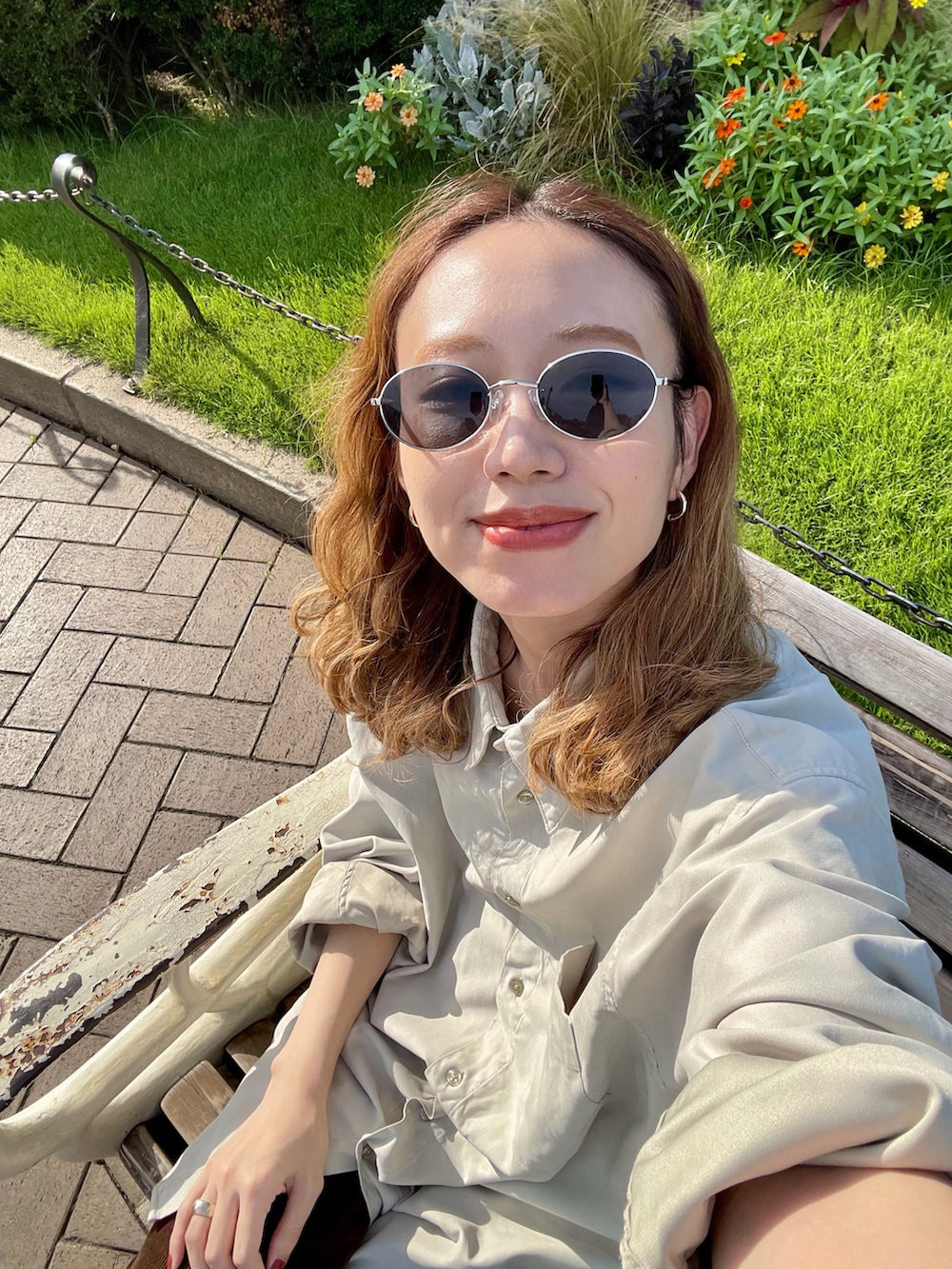 ベージュ系のシャツ/ブラウス、ブラウン系のパンツ、ブラック系のハンドバッグを着用したレディースの秋コーディネートの2枚目の写真